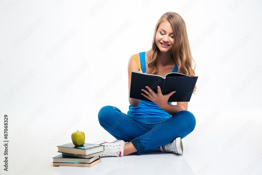 Girl sitting on the floor and writing notes Girl sitting on the floor and writing notes