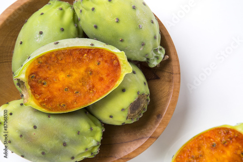 A couple of Figs of India in a wooden pot over a wooden surface.