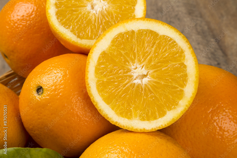 Close up of some oranges in a basket over a wooden surface Close up of some oranges in a basket over a wooden surface