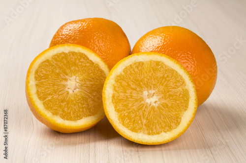 Close up of some oranges in a basket over a wooden surface