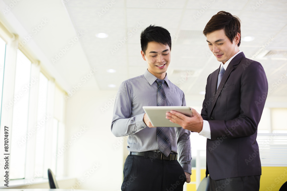 business partners looking at tablet and discussing business partners looking at tablet and discussing