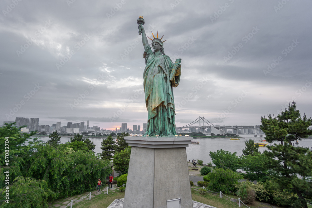 Fototapeta premium Statue of Liberty and Rainbow bridge in Odaiba at sunset