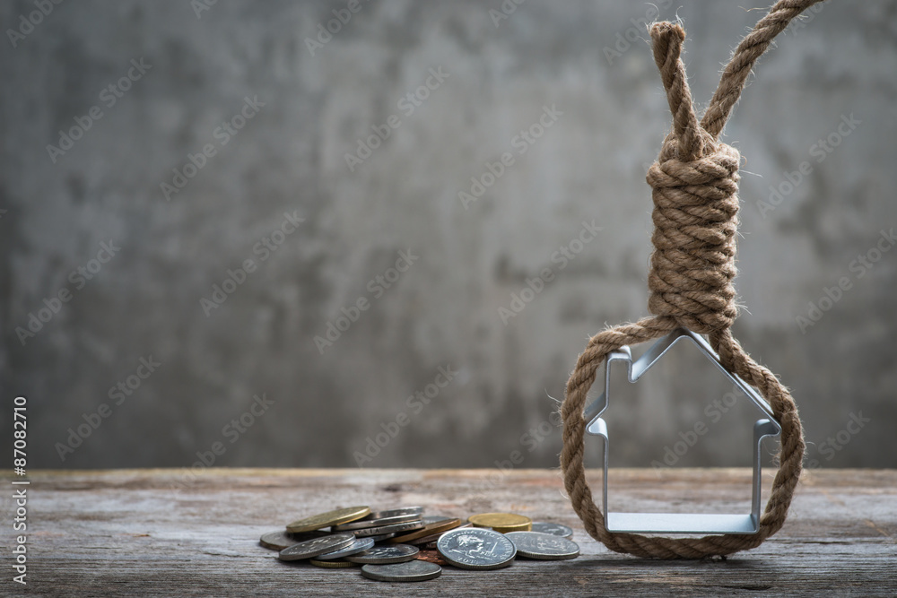 Fototapeta premium Hangman's noose with house and money on brown wooden surface