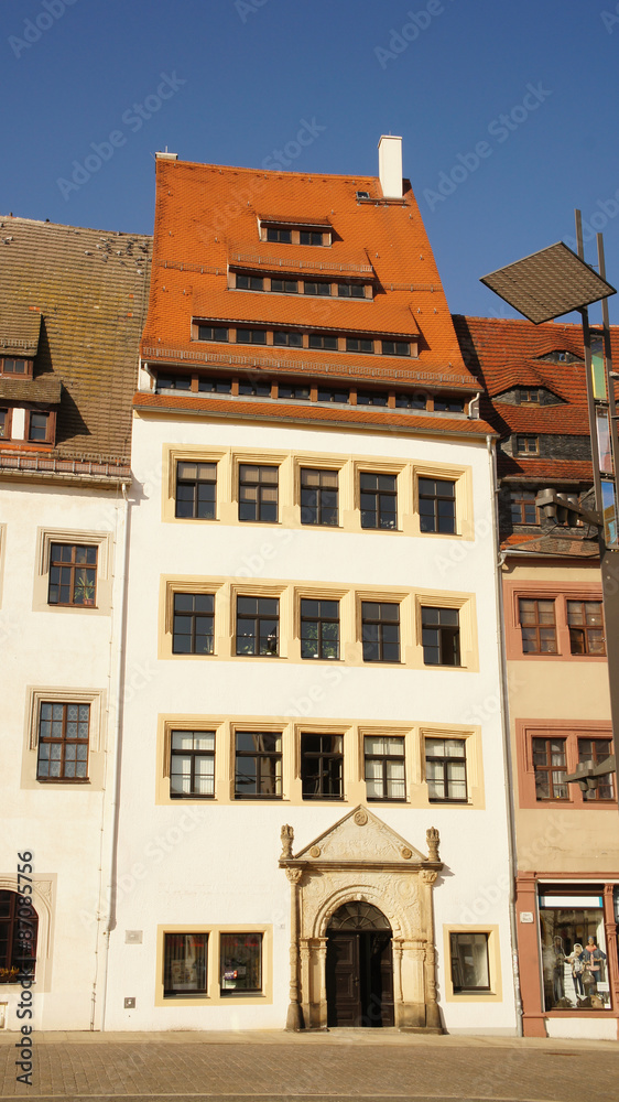 Altes Bürgerhaus/Historisches Bügerhaus mit  rotem Ziegeldach und mehrgeschossigen Dachgauben auf dem Obermarkt in Freiberg in Sachsen, tiefblauer, wolkenloser Himmel