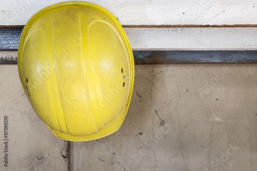 Yellow safety helmet hangs on a shelf