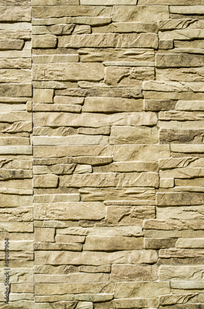 Fototapeta premium Decorative relief cladding slabs imitating stones on wall