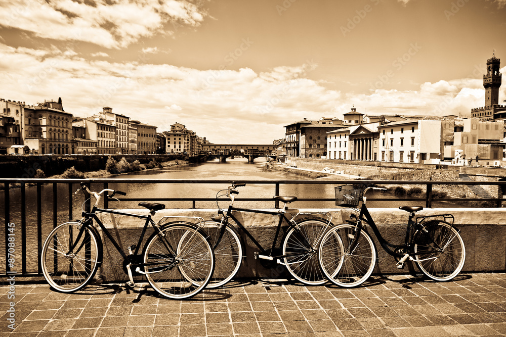 three bikes photographed on the bridge over the River Arno , Florence , Italy 

