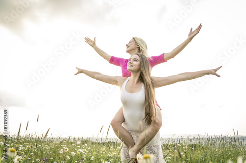 riends having fun in a daisy field photo