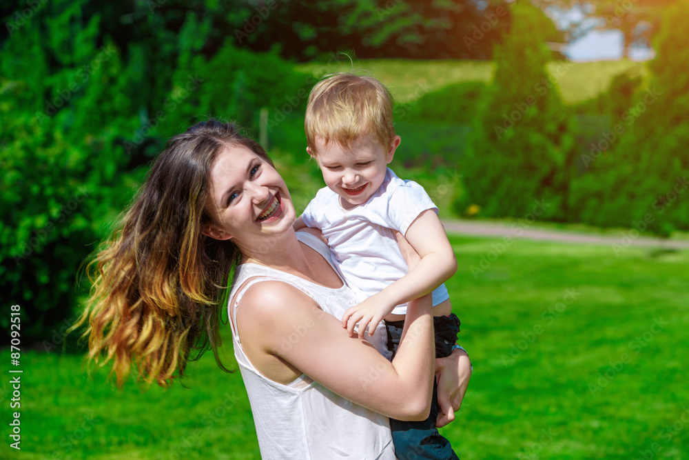 Cute cheerful child with mother play outdoors Cute cheerful child with mother play outdoors