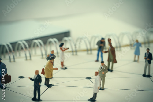 close up of miniature people with social network diagram on open