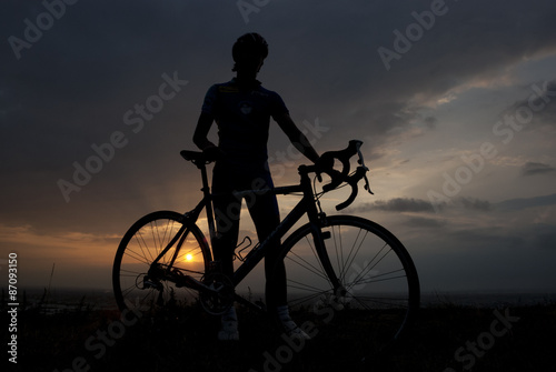 Silhouette of a biker with his bicycle at sunset
