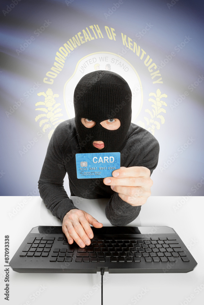 Hacker holding credit card with US state flag on background - Kentucky Hacker holding credit card with US state flag on background - Kentucky