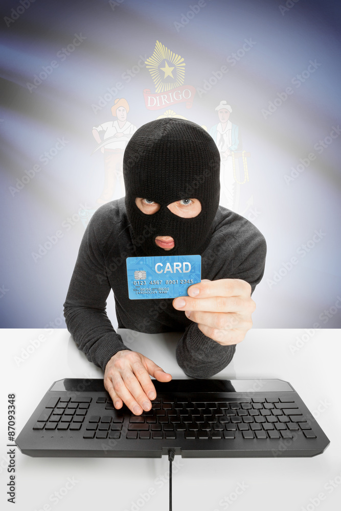 Hacker holding credit card with US state flag on background - Maine Hacker holding credit card with US state flag on background - Maine