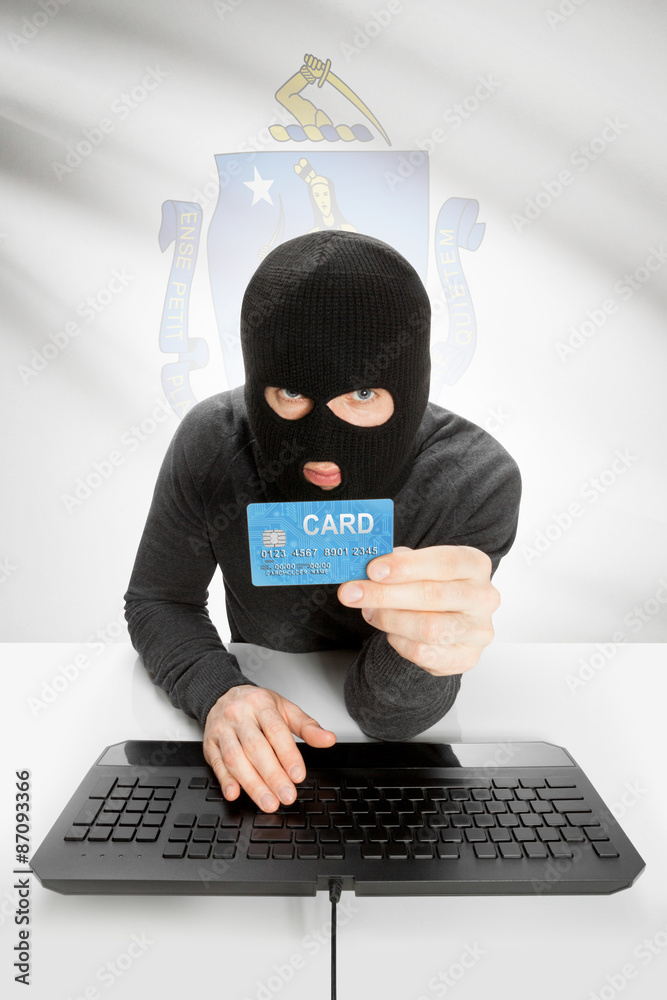 Hacker holding credit card with US state flag on background - Massachusetts