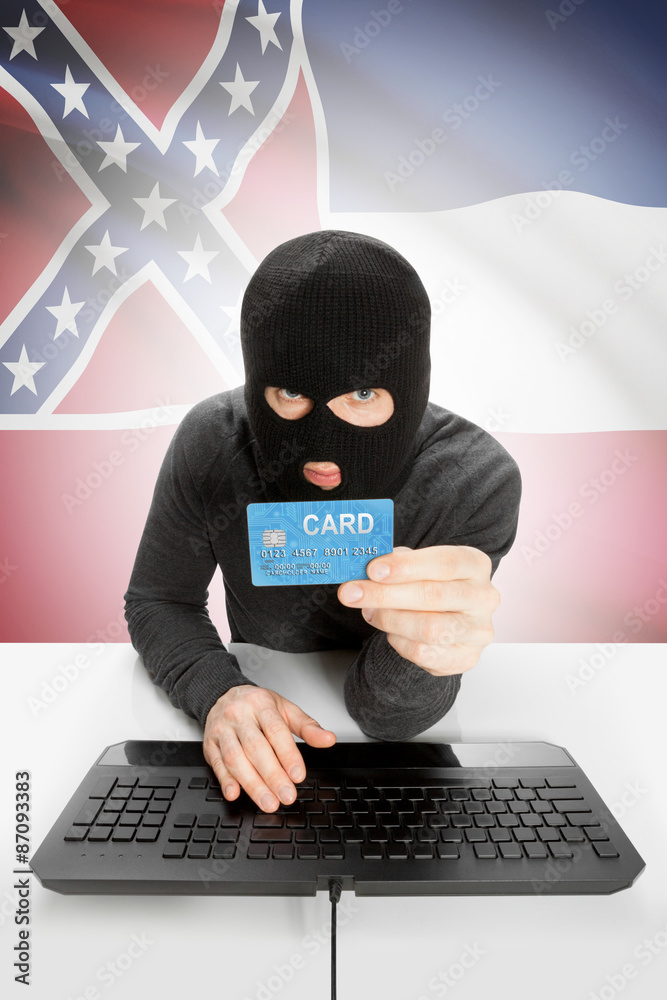 Hacker holding credit card with US state flag on background - Mississippi Hacker holding credit card with US state flag on background - Mississippi