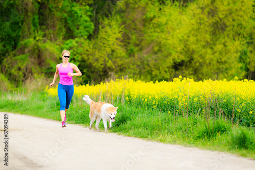 Woman running in summer park with dog