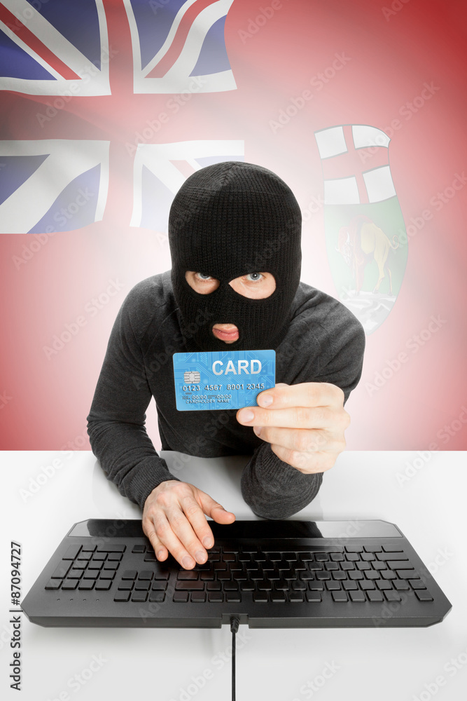Hacker with credit card in hand and Canadian province flag on background - Manitoba Hacker with credit card in hand and Canadian province flag on background - Manitoba