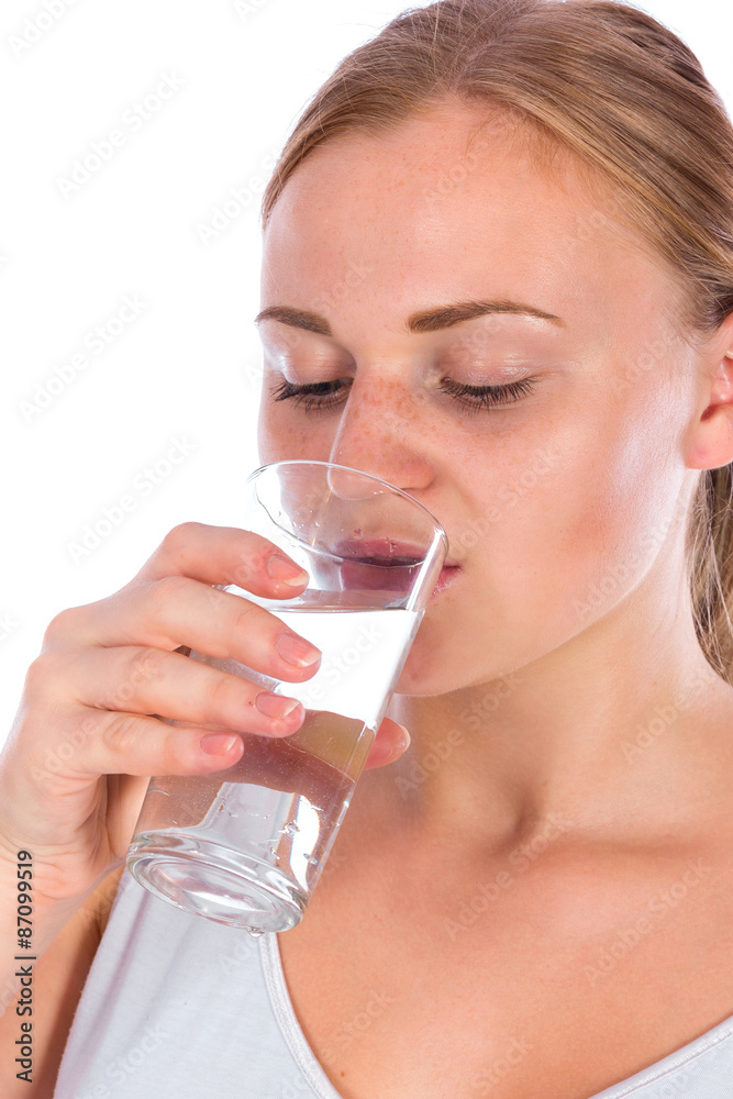 Portrait of a young happy girl drinking water from glass after fitness, isolated on a white background Portrait of a young happy girl drinking water from glass after fitness, isolated on a white background