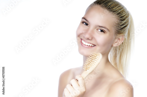 Smiling beautiful young woman holding hairbrush