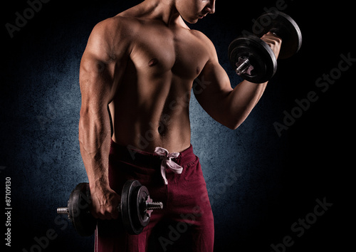 Fotografia Handsome power athletic man with dumbbell confidently looking fo