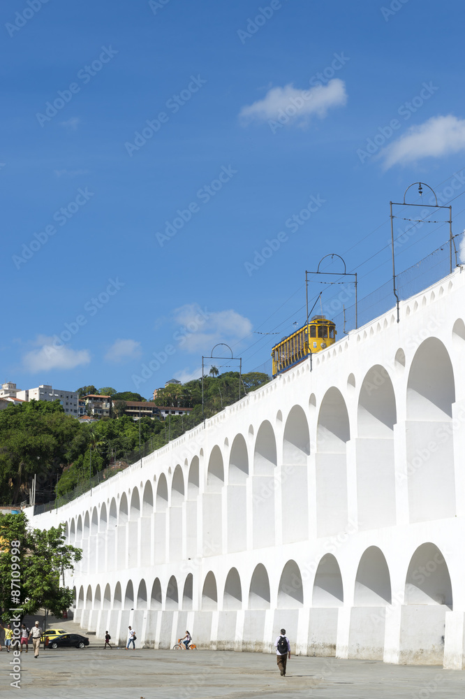 Bonde de Santa Teresa tram train drives along landmark white arches of Arcos da Lapa in Centro of Rio de Janeiro Brazil