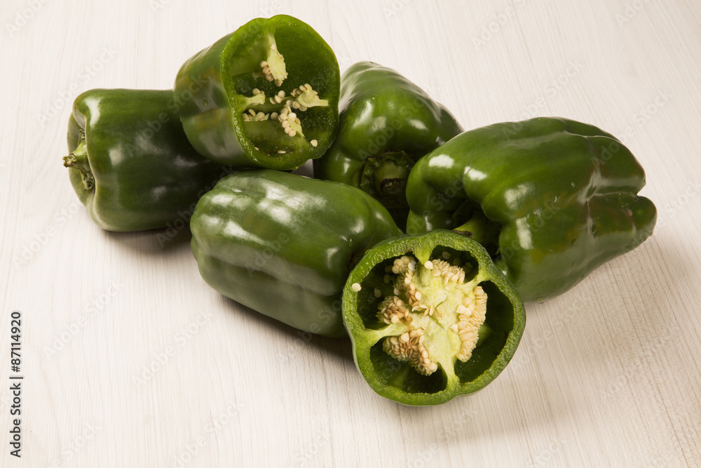 Some red, green and yellow peppers over a wooden surface Some red, green and yellow peppers over a wooden surface