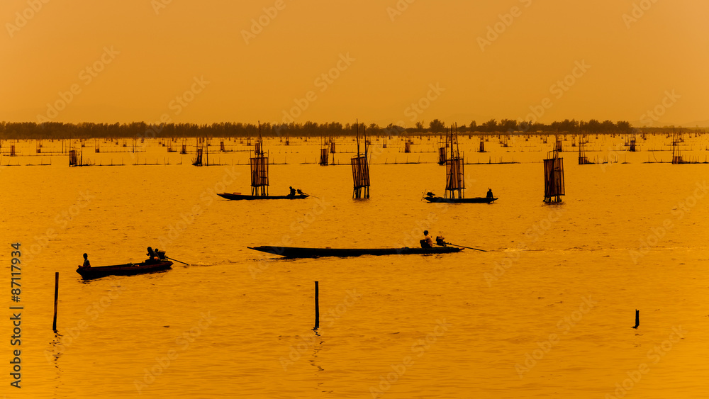 silhouette of fishermen with thier boats fishing in the lake. silhouette of fishermen with thier boats fishing in the lake.
