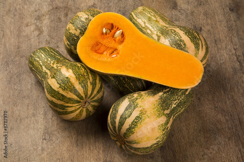 Some Paulistan pumpkins in a basket over a wooden surface on a p photo