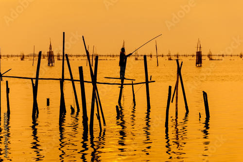 silhouette of fishermen with fishing in the lake.
