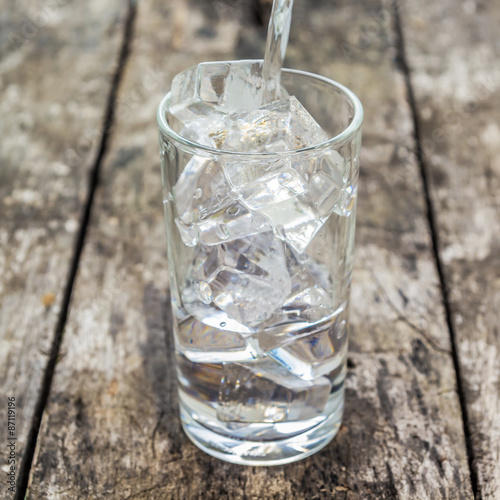 Pour water into a glass of ice