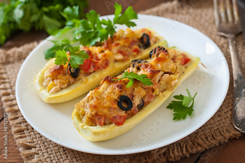 Stuffed zucchini with chicken, tomatoes and olives with cheese crust