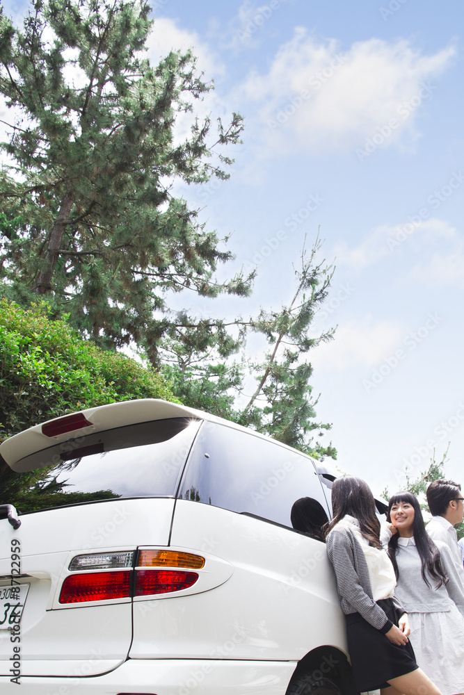 Fototapeta premium 車の前に立つ学生たち