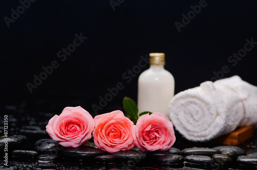 Three rose and towel with massage oil and therapy stones 