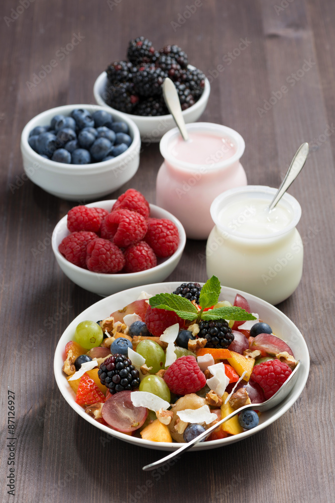 fruit salad, fresh berries and yoghurts on a wooden table fruit salad, fresh berries and yoghurts on a wooden table