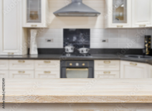 Wooden textured table over blurred kitchen vintage interior background