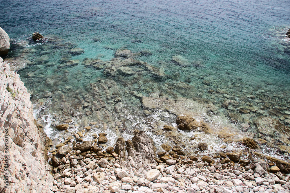Obraz premium Stones on the beach and in the clear water