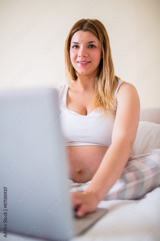 Pregnant woman using laptop computer Pregnant woman using laptop computer