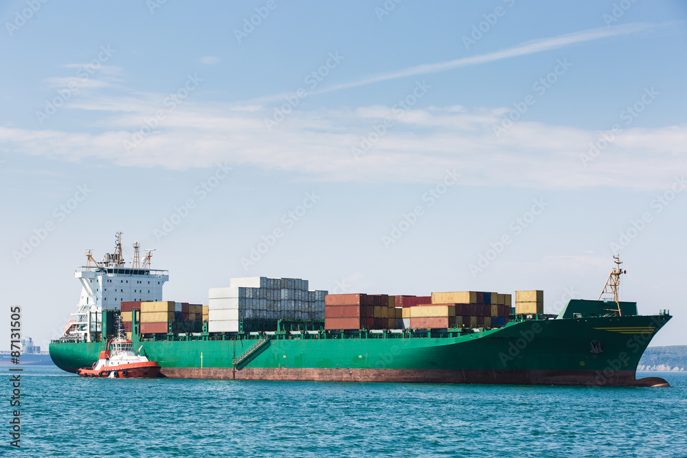 Big container ship with towboat
