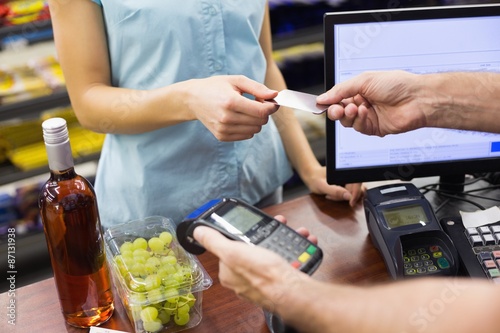 Woman at cash register paying with credit card photo
