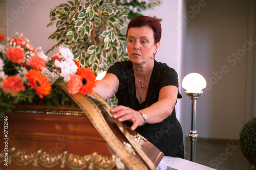 The master of ceremonies prepares a coffin and flowers for burial in a ceremony hall