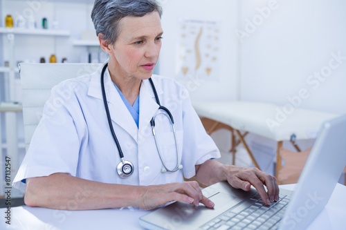 Serious female doctor using her laptop computer 