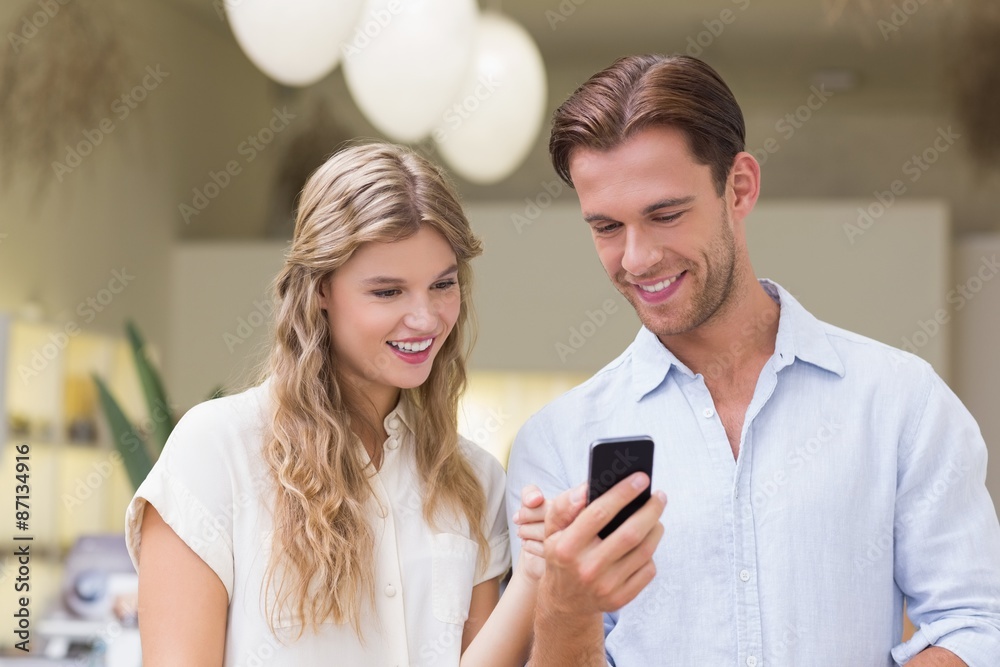 A happy couple looking at smartphone A happy couple looking at smartphone