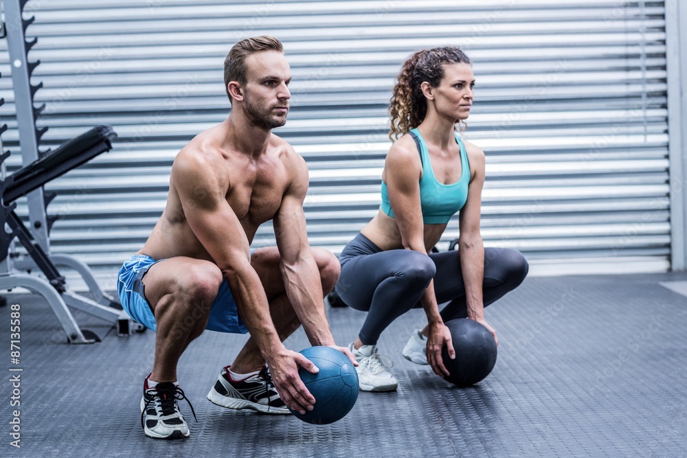 Obraz premium Muscular couple doing ball exercise