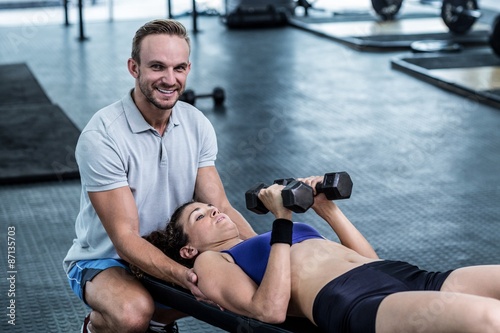 A muscular woman about to lift dumbbells