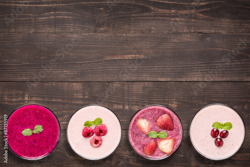 Set of fruit smoothie in glasses on wooden background.