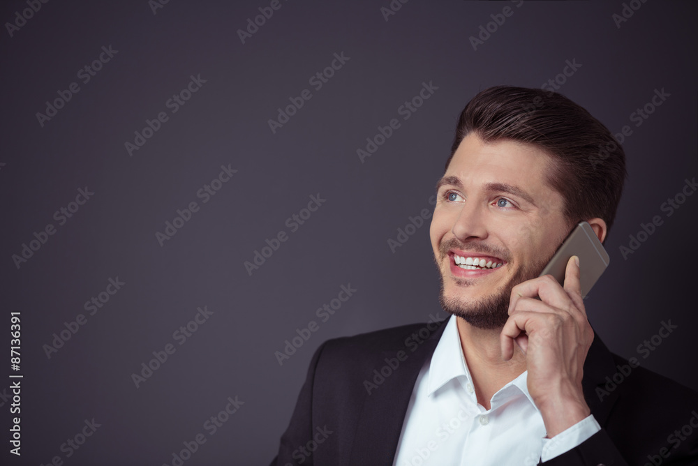 mann telefoniert mit seinem handy vor grauem hintergrund