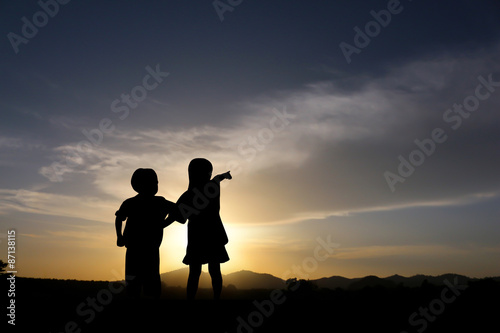 Sister and brother at sunset.