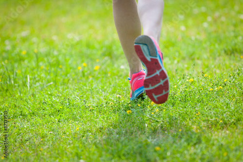  Young women jogging at park . Close-up photo of her legs