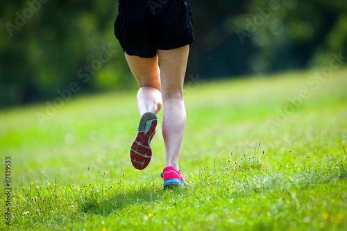  Young women jogging at park . Close-up photo of her legs