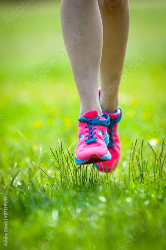  Young women jogging at park . Close-up photo of her legs